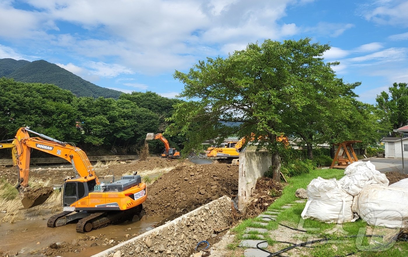 본문 이미지 - 폭우로 유실된 전북 완주군 운주면 운주초등학교 인근 하천에서 중장비가 복구 작업에 나서고 있다. 2024.7.14/뉴스1 강교현 기자
