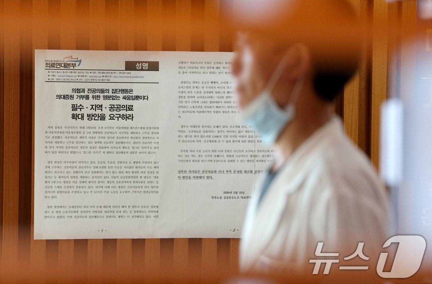 본문 이미지 - 정부가 요구한 전공의 복귀·사직 시한을 하루 앞둔 14일 오전 서울 종로구 서울대병원에서 의사가 민주노총 의료연대본부가 부착한 성명서 앞으로 지나가고 있다. 2024.7.14/뉴스1 ⓒ News1 장수영 기자
