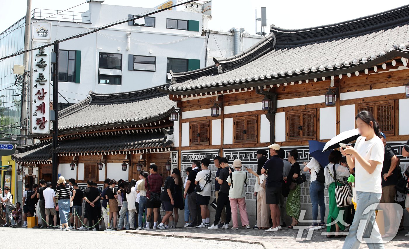 초복을 하루 앞둔 14일 서울 종로구의 한 삼계탕 전문점을 찾은 시민들이 길게 줄을 지어 입장 순서를 기다리고 있다. 2024.7.14/뉴스1 ⓒ News1 오대일 기자