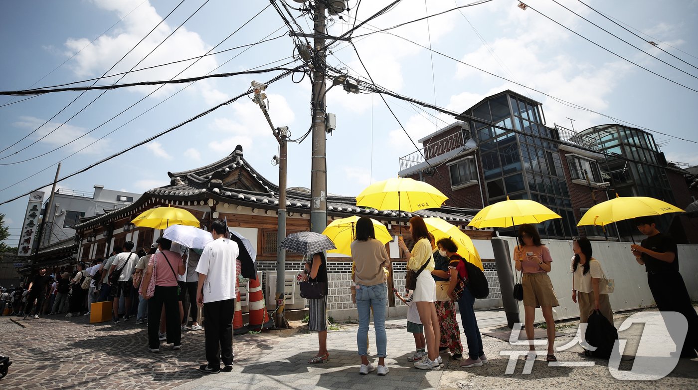 초복을 하루 앞둔 14일 서울 종로구의 한 삼계탕 전문점을 찾은 시민들이 길게 줄을 지어 입장 순서를 기다리고 있다. 2024.7.14/뉴스1 ⓒ News1 오대일 기자