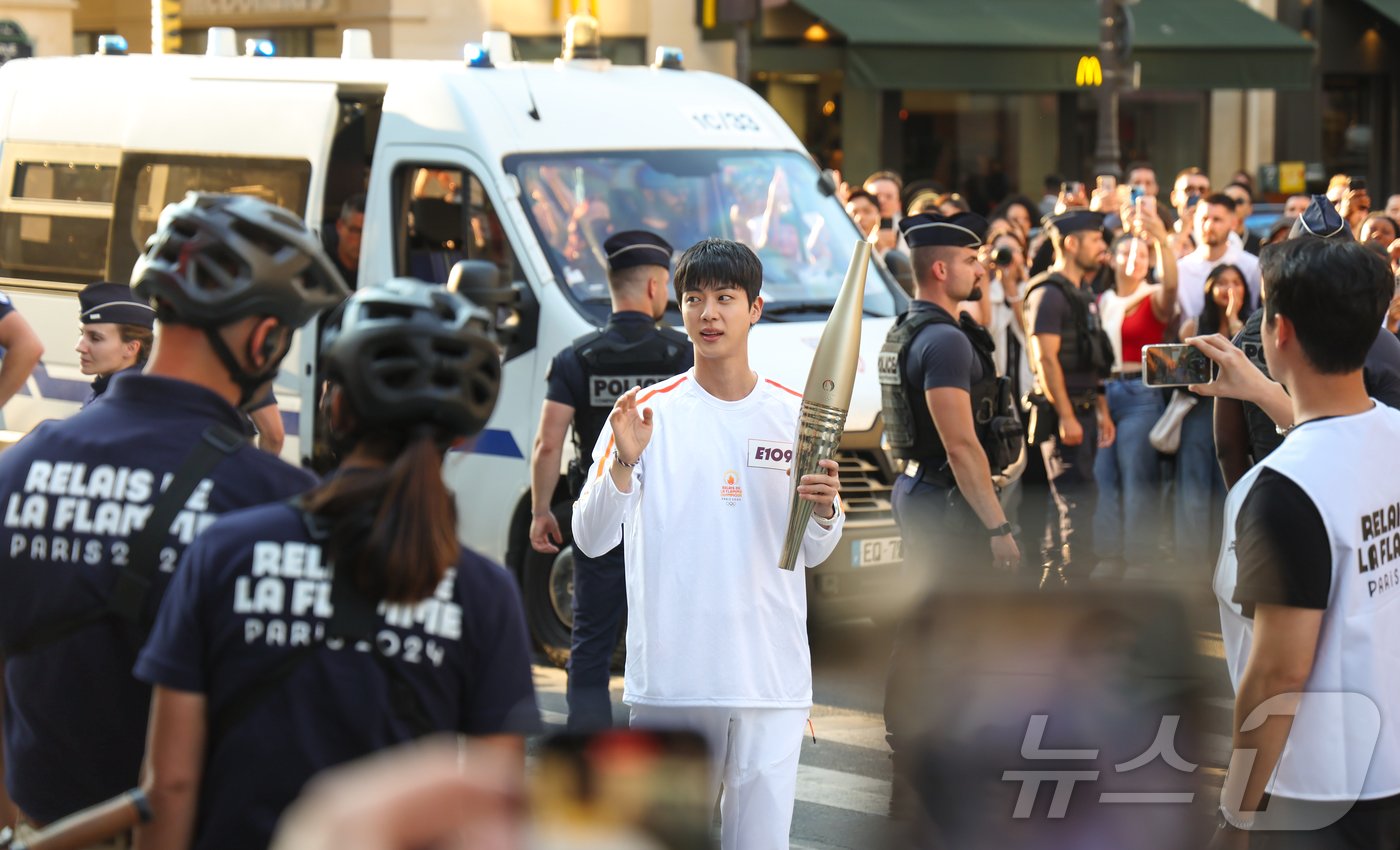 본문 이미지 - 2024 파리 올림픽 성화 봉송 주자로 나선 아이돌 그룹 방탄소년단&#40;BTS&#41;의 맏형 진이 프랑스 혁명기념일인 14일&#40;현지시간&#41; 프랑스 파리 루브르 박물관 인근 도로에서 관중들에게 인사하고 있다. 2024.7.15/뉴스1 ⓒ News1 이준성 기자