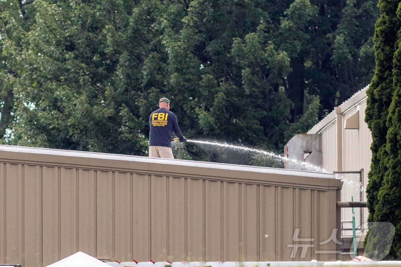 본문 이미지 - 14일(현지시간) 미국 펜실베이니아주 버틀러에서 도널드 트럼프 공화당 후보를 저격한 총격 용의자 매튜 크룩스가 사살당한 현장을 FBI 직원이 물로 청소하고 있다. 2024.07.14 ⓒ 로이터=뉴스1 ⓒ News1 정지윤 기자