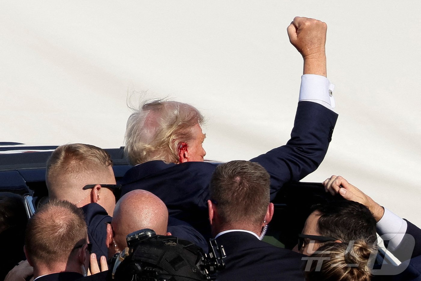 본문 이미지 - 13일(현지시간) 도널드 트럼프 미국 전 대통령이 피격된 후 귀에서 피를 흘린 채 지지자들을 향해 불끈 쥔 주먹을 들어보이고 있다. 2024.07.13 ⓒ 로이터=뉴스1 ⓒ News1 정지윤 기자