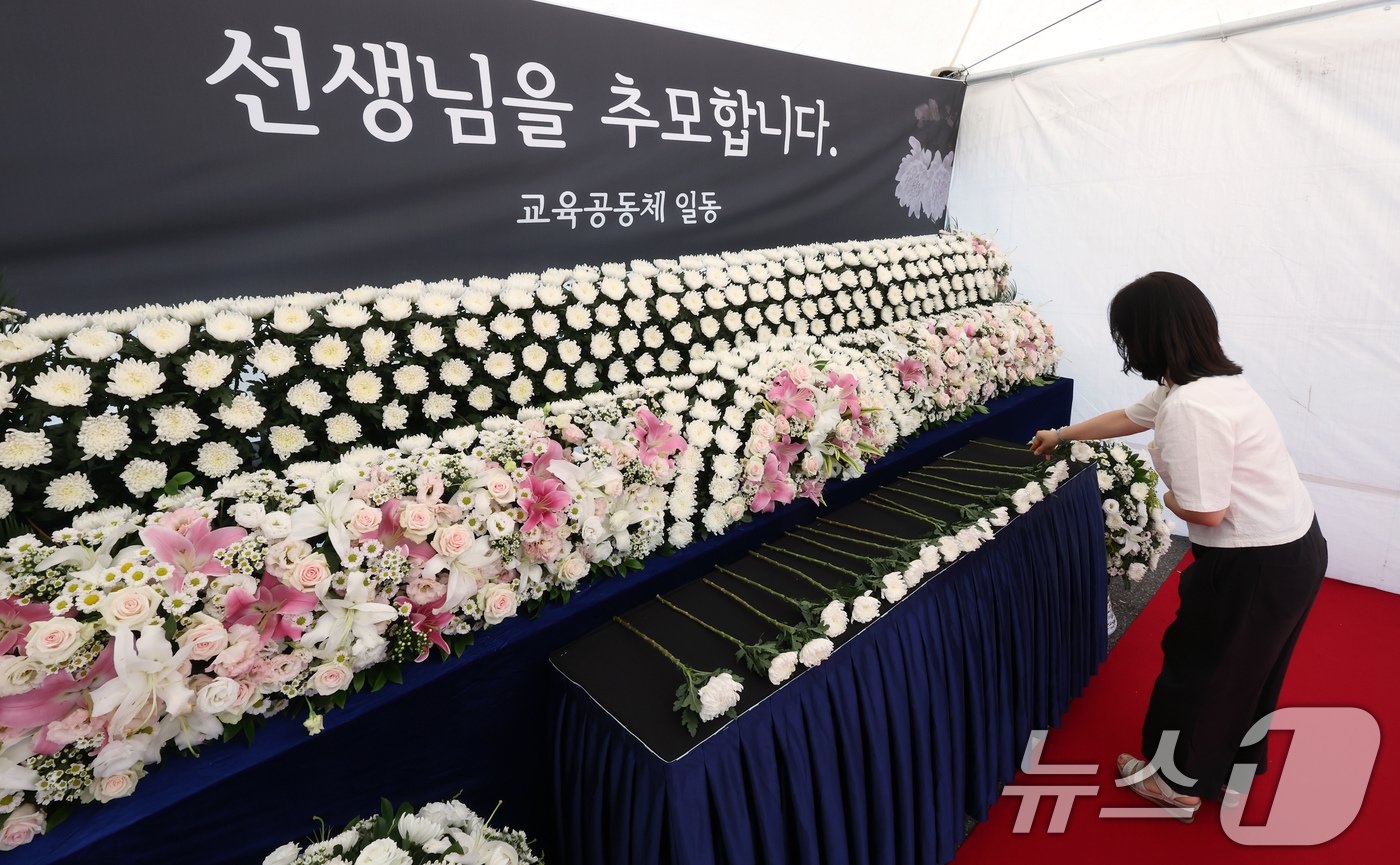 본문 이미지 - 서이초 교사 순직 1주기(18일)를 앞둔 15일 서울 종로구 서울시교육청에 마련된 서이초 교사 1주기 추모 공간을 찾은 교육청 직원들이 헌화를 하고 있다.2024.7.15/뉴스1 ⓒ News1 박정호 기자