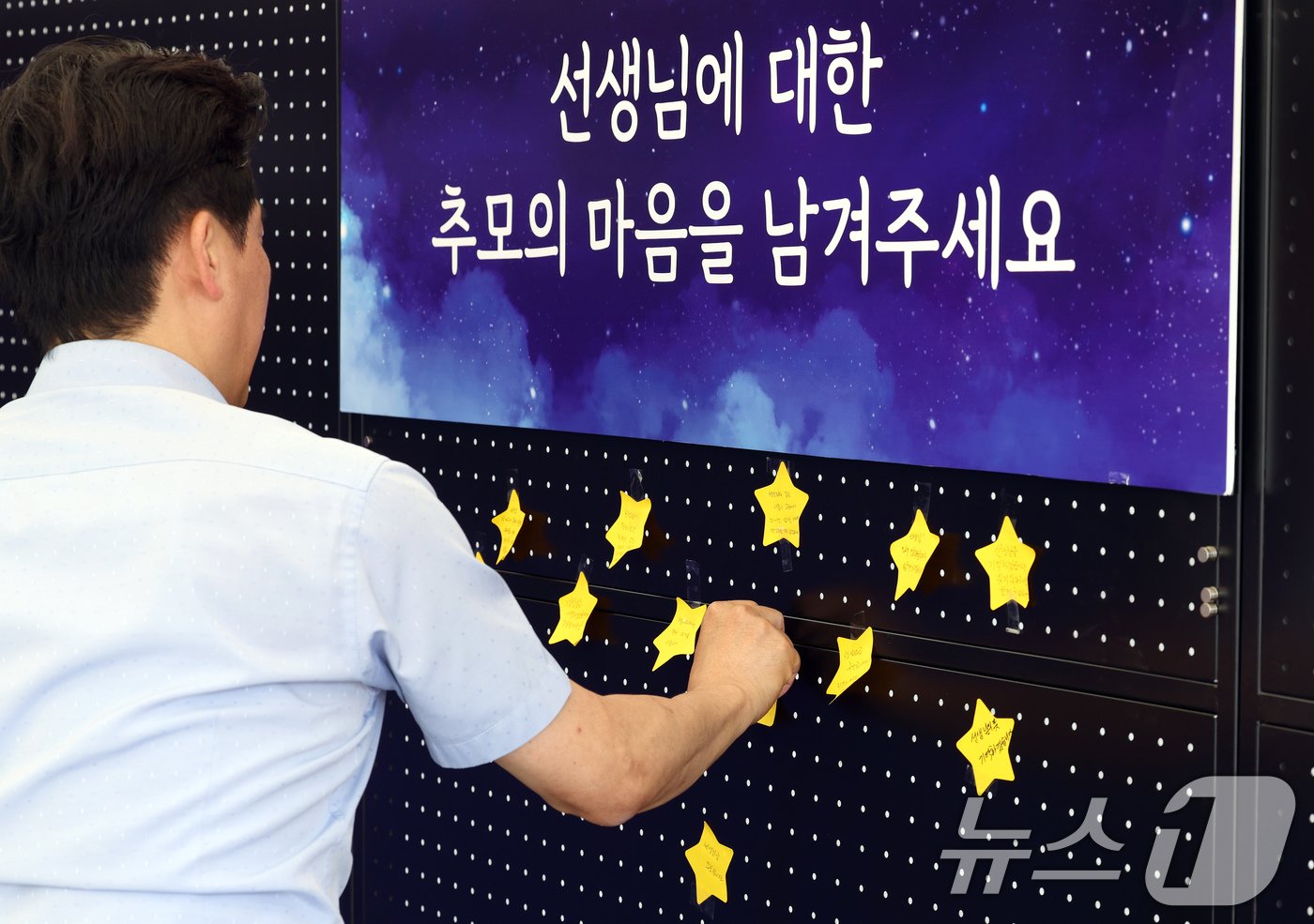 본문 이미지 - 서이초 교사 순직 1주기(18일)를 앞둔 15일 서울 종로구 서울시교육청에 마련된 서이초 교사 1주기 추모 공간에서 교육청 직원이 추모의 마음을 담아 쓴 글을 붙이고 있다. 2024.7.15/뉴스1 ⓒ News1 박정호 기자