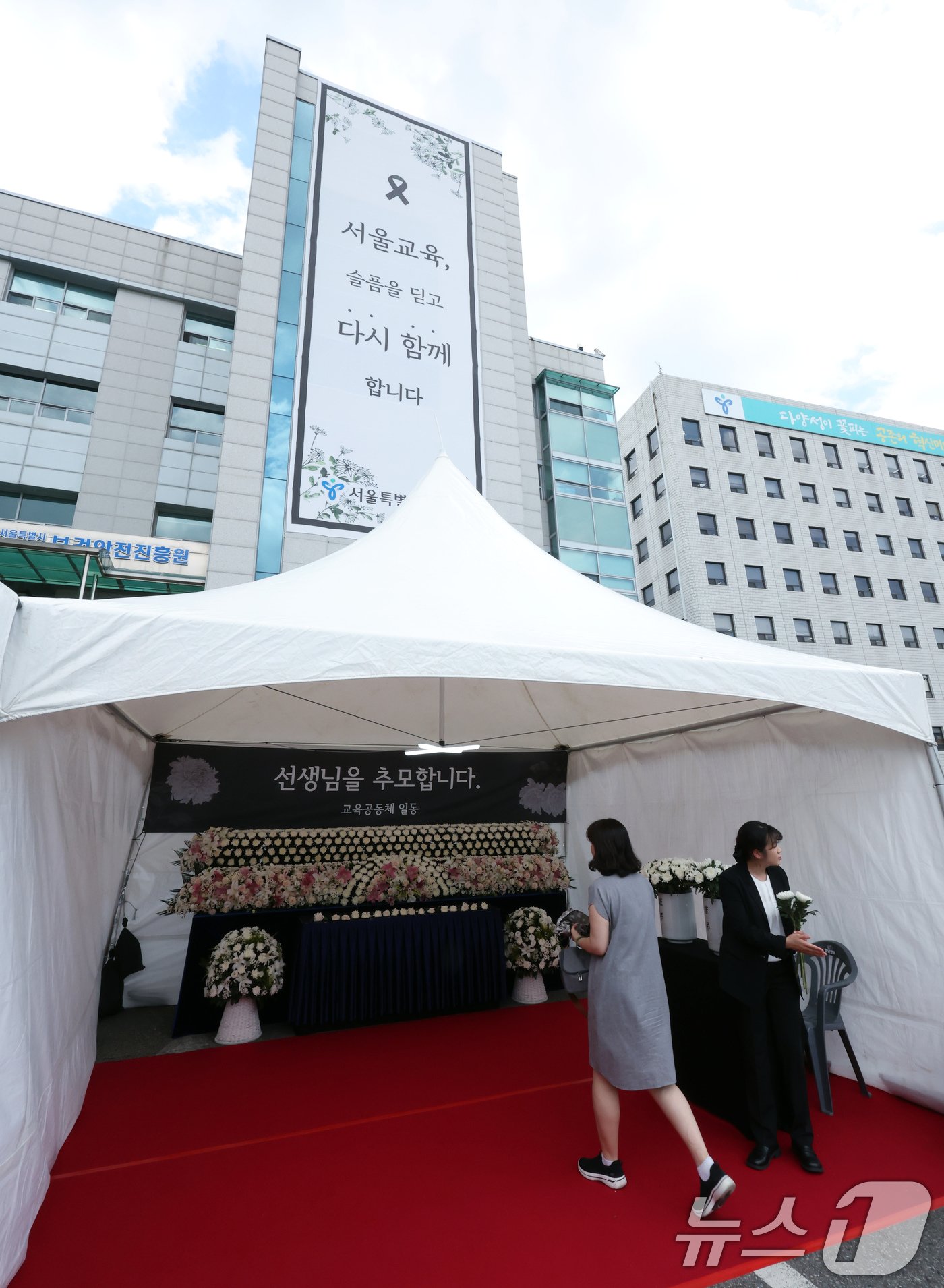 본문 이미지 - 서이초 교사 순직 1주기(18일)를 앞둔 15일 서울 종로구 서울시교육청에 마련된 서이초 교사 1주기 추모 공간을 찾은 시민이 헌화를 위해 이동하고 있다. 2024.7.15/뉴스1 ⓒ News1 박정호 기자