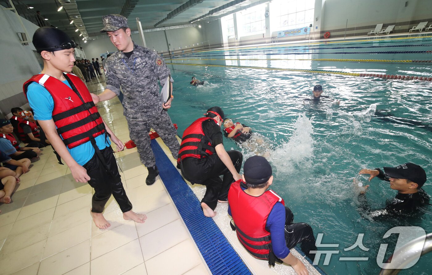 본문 이미지 - SSU(해군해난구조전대) 대원들이 16일 오전 제주 서귀포시 강정동 해군 김영관센터 수영장에서 강정초등학교 학생들에게 생존수영을 가르치고 있다. 해군이 초등학생 생존수영 교육을 지원하는 것은 이번이 전국 최초다. 2024.7.16/뉴스1 ⓒ News1 오현지 기자