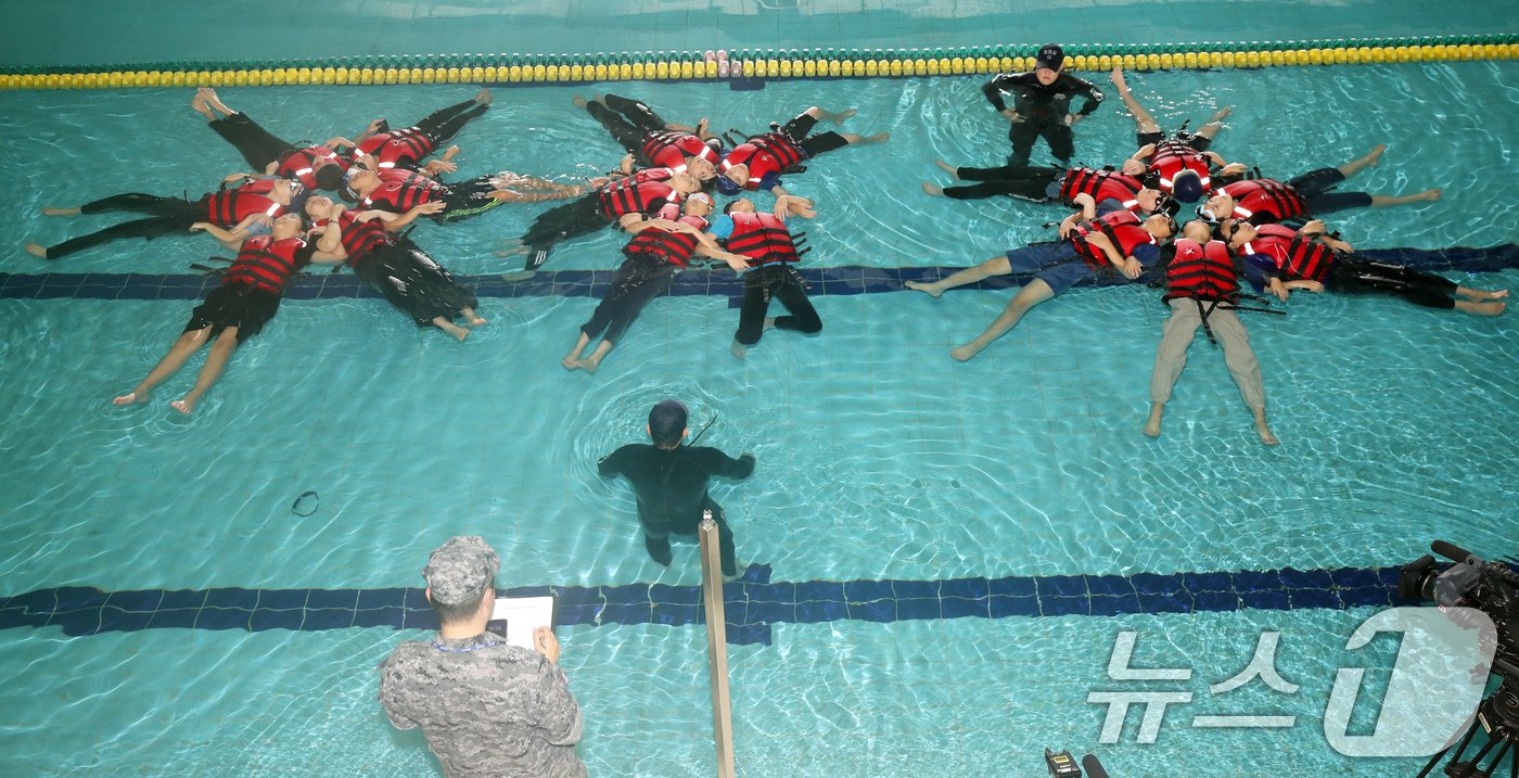 본문 이미지 - SSU(해군해난구조전대) 대원들이 16일 오전 제주 서귀포시 강정동 해군 김영관센터 수영장에서 강정초등학교 학생들에게 생존수영을 가르치고 있다. 해군이 초등학생 생존수영 교육을 지원하는 것은 이번이 전국 최초다. 2024.7.16/뉴스1 ⓒ News1 오현지 기자