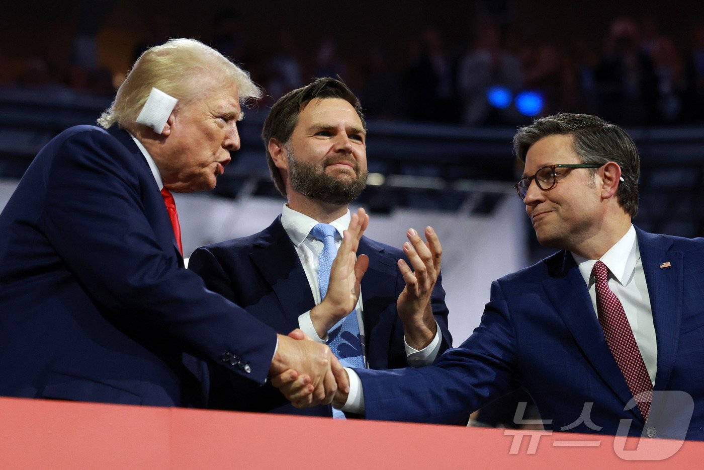 본문 이미지 - 15일(현지시간) 미국 위스콘신주 밀워키에서 열린 공화당 전당대회에 참석한 도널드 트럼프(왼쪽) 전 미국 대통령과 마이크 존슨(오른쪽) 하원의장이 악수하고 있다. 가운데는 J.D. 밴스 공화당 부통령 후보. 2024.07.15. ⓒ AFP=뉴스1 ⓒ News1 장시온 기자