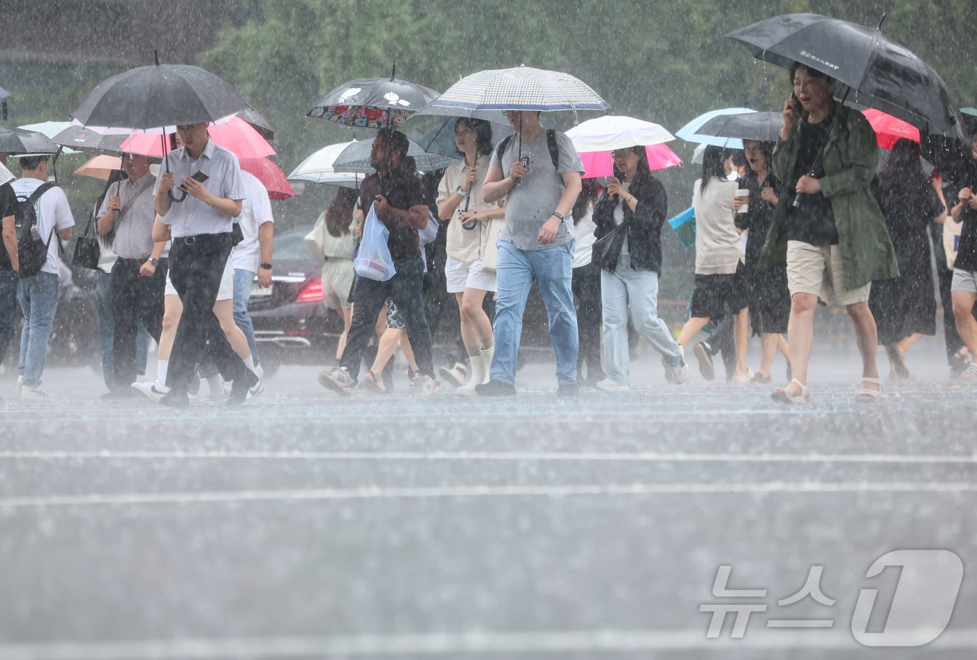 서울을 비롯한 수도권지역에 호우특보가 내려진 17일 서울 종로구 광화문사거리에서 우산을 쓴 시민들이 발걸음을 재촉하고 있다. 2024.7.17/뉴스1 ⓒ News1 김도우 기자