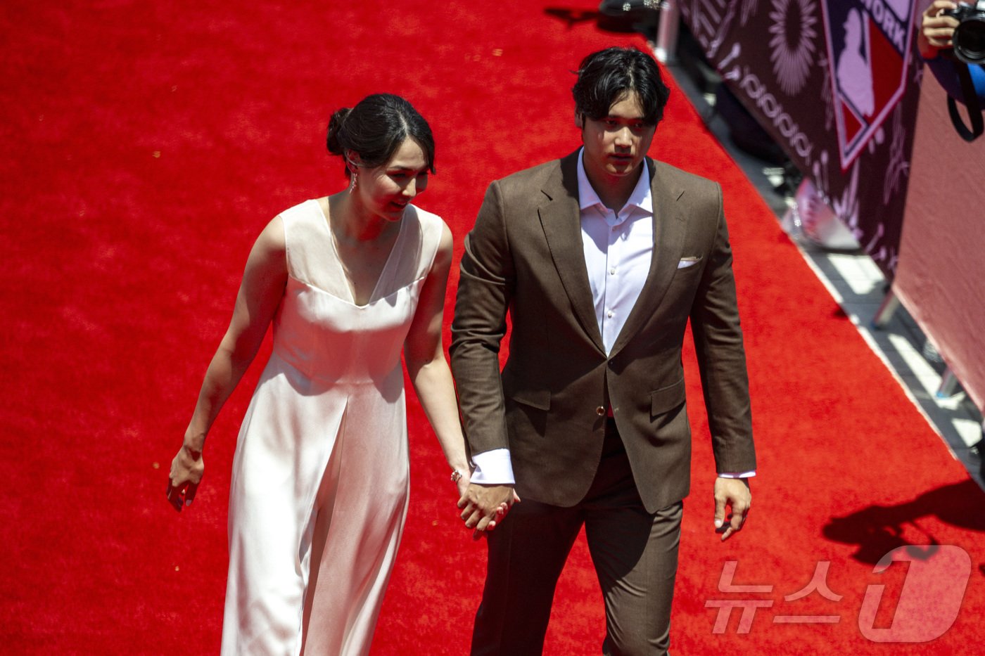 본문 이미지 - 오타니 부부가 올스타전을 앞두고 많은 스포트라이트를 받으며 경기장에 입장하고 있다. ⓒ 로이터=뉴스1