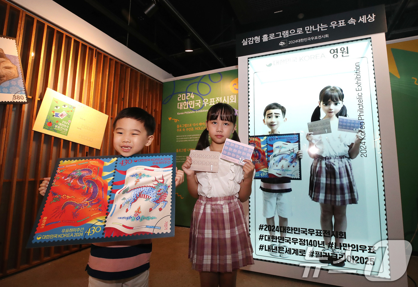 (서울=뉴스1) 임세영 기자 = 18일 오전 서울 용산구 노들섬 노들갤러리에서 열린 '2024 대한민국 우표전시회'에서 어린이 모델들이 '홀로그램 실감형 우표'를 선보이고 있다. …