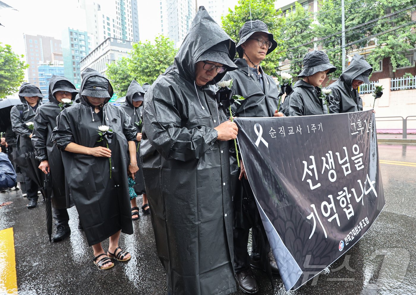 서이초등학교 교사 사망 1주기인 18일 오전 서울 서초구 서이초교사거리에서 교사유가족협의회 관계자와 전국교직원노동조합 조합원들이 서초경찰서 방향으로 행진하기 전 묵념하고 있다. 2024.7.18/뉴스1 ⓒ News1 김도우 기자