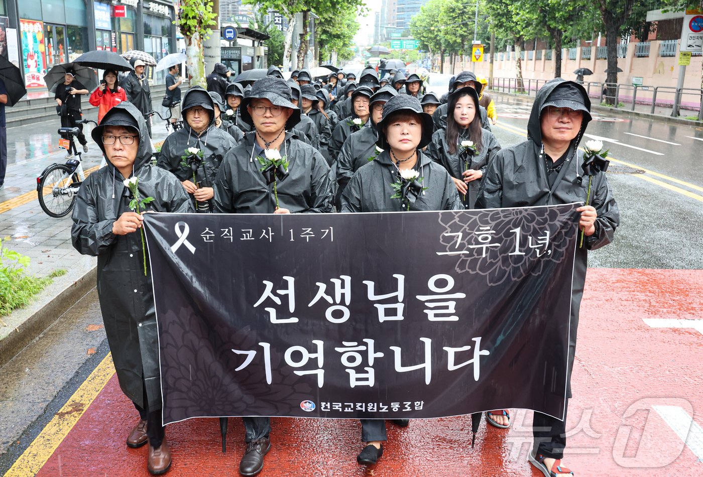 본문 이미지 - 서이초등학교 교사 사망 1주기인 18일 오전 서울 서초구 서이초교사거리에서 교사유가족협의회 관계자와 전국교직원노동조합 조합원들이 고인을 추모하며 서초경찰서 방향으로 행진하고 있다. 2024.7.18/뉴스1 ⓒ News1 김도우 기자