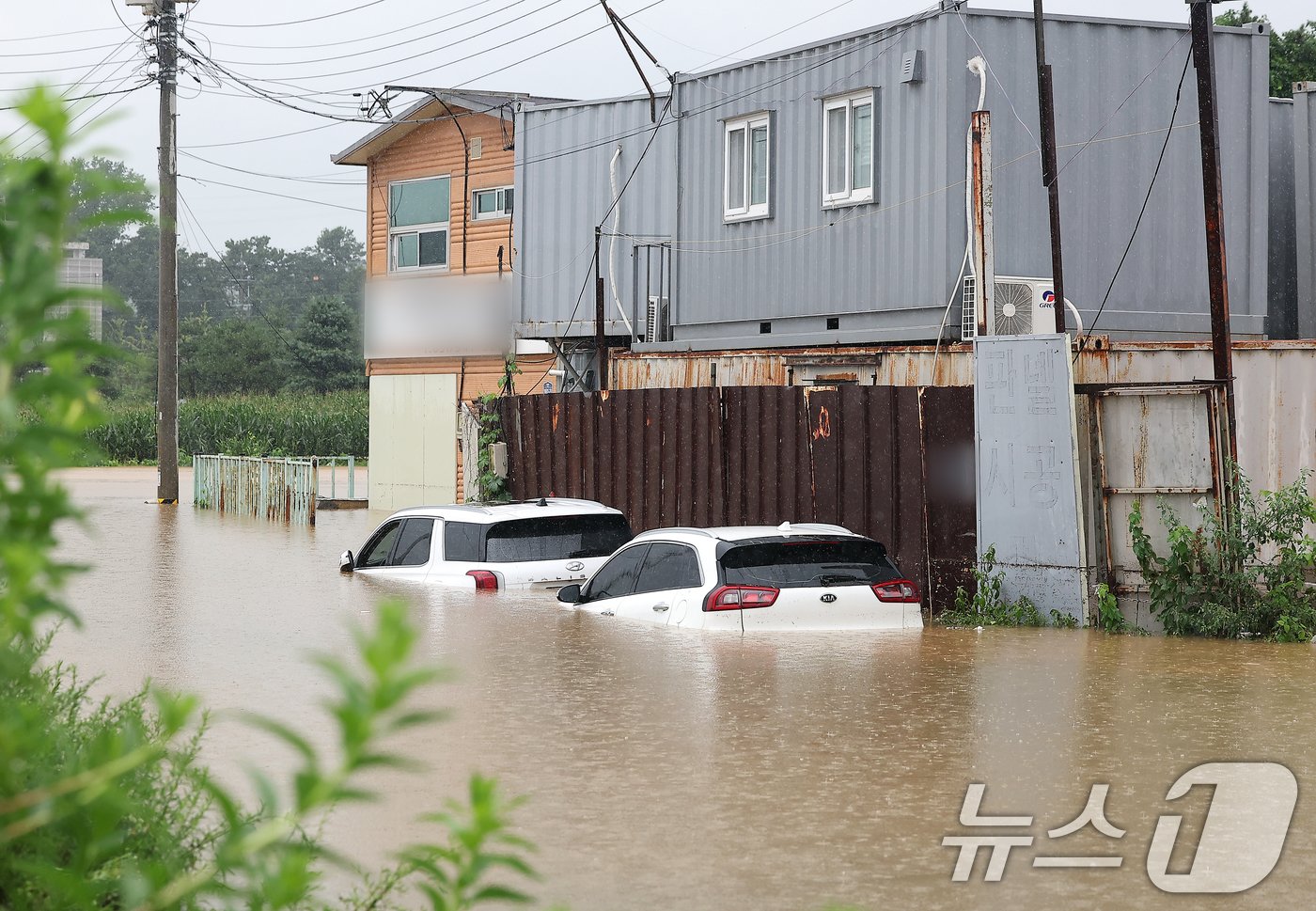 본문 이미지 - 경기 북부 지역에 호우 특보가 내려진 18일 경기 파주시 월릉면의 한 컨테이너 제작공장이 침수돼 주차된 차량이 물에 잠겨 있다.  2024.7.18/뉴스1 ⓒ News1 김진환 기자