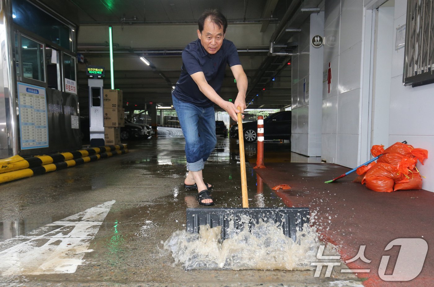 18일 호우경보가 발령된 충남 당진전통시장에서 침수 피해가 잇따르는 가운데 공용주차장에서 관계자가 고인 물을 정리하고 있다. 2024.7.18/뉴스1 ⓒ News1 김기태 기자