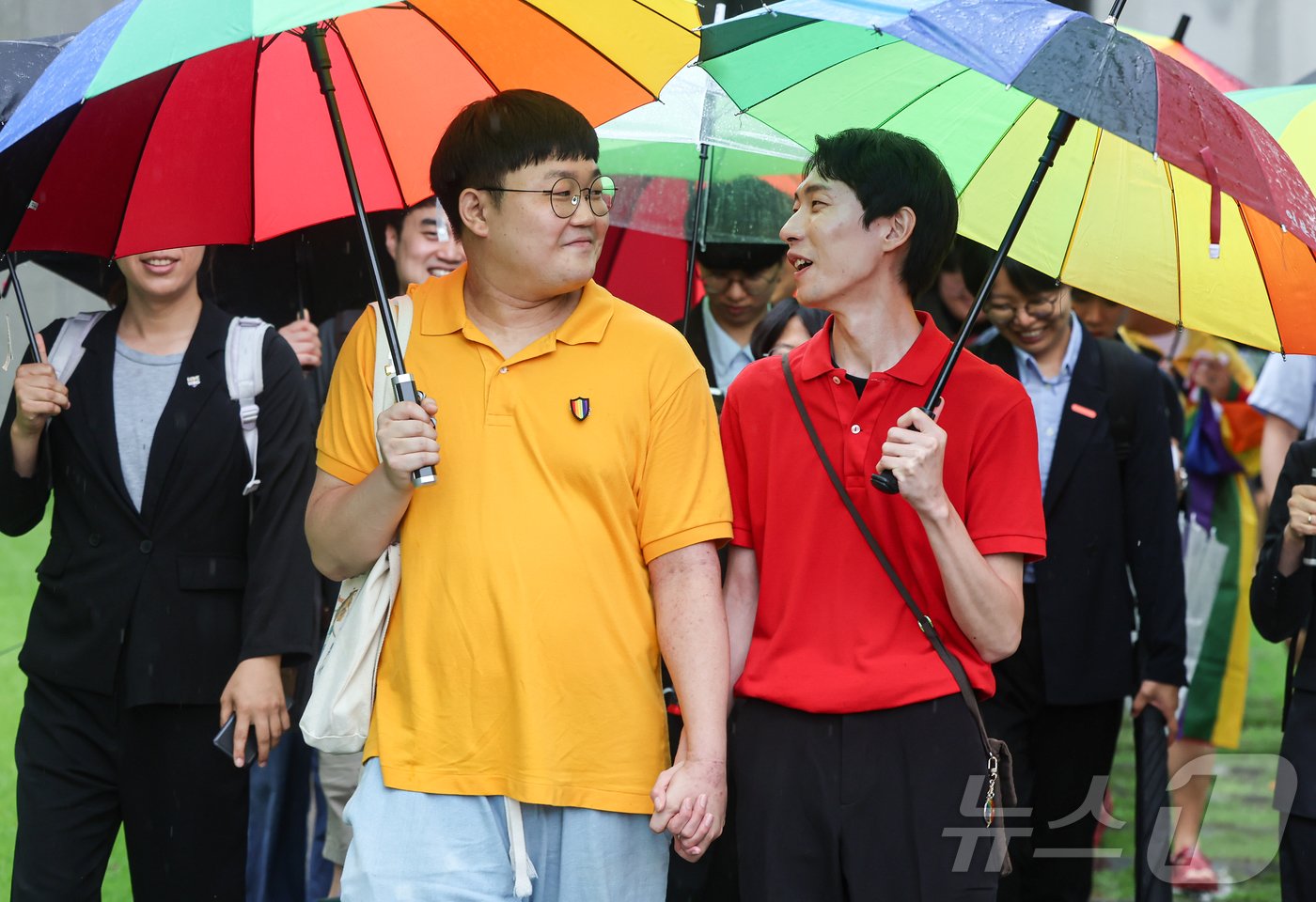 본문 이미지 - 동성 부부 소성욱씨와 김용민씨가 18일 서울 서초구 대법원 앞에서 취재진에 소감을 밝힌뒤 나서고 있다. 이날 대법원 전원합의체는 소성욱씨가 국민건강보험공단을 상대로 낸 보험료부과처분 취소소송 상고심에서 원고 승소 판결한 원심을 확정했다. 2024.7.18/뉴스1 ⓒ News1 김도우 기자