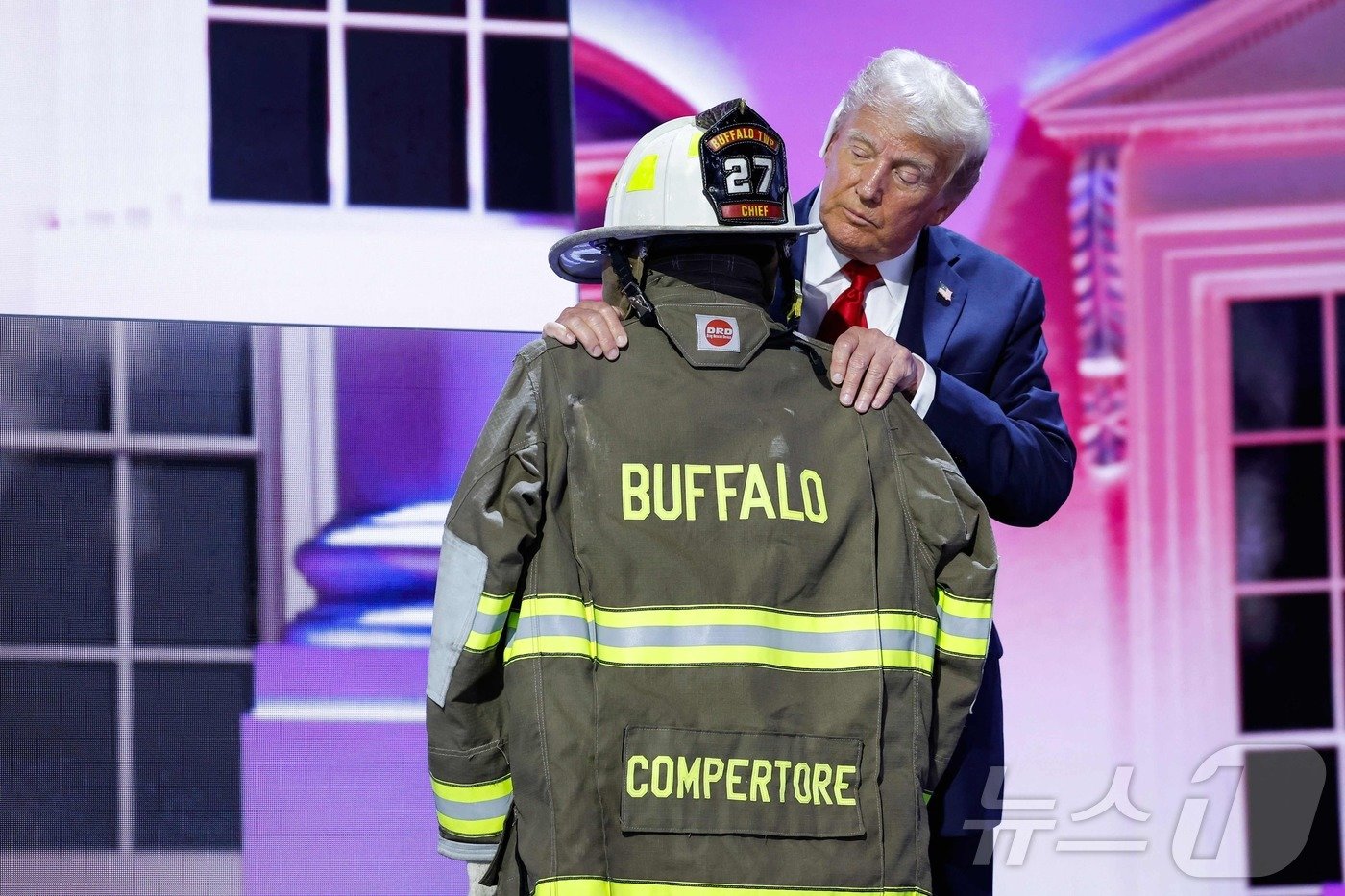 본문 이미지 - 도널드 트럼프 전 미국 대통령이 18일(현지시간) 위스콘신주 밀워키에서 열린 공화당 전당대회 마지막 날 암살 미수 총격 사건의 희생자 코리 콤페라토레의 소방관 헬멧과 재킷을 안고 있다. 2024.07.19 ⓒ AFP=뉴스1 ⓒ News1 우동명 기자