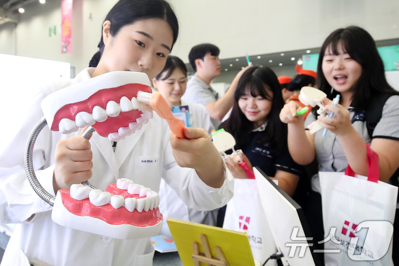 본문 이미지 - 19일 오전 대구 북구 엑스코에서 열린 '제15회 대구진로진학박람회'를 찾은 학생들이 한 대학 부스에서 올바른 칫솔질 등 구강위생 관리법을 배우고 있다. (사진은 기사 내용과 무관함) / ⓒ 뉴스1 공정식 기자