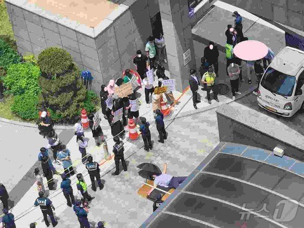 본문 이미지 - 지난 6월 전남 광양의 한 아파트 입주민이 할인 분양에 반대하며 해당 세대 이사 차량 진입을 막고 있다.(온라인 커뮤니티 캡처)2024.7.19/뉴스1