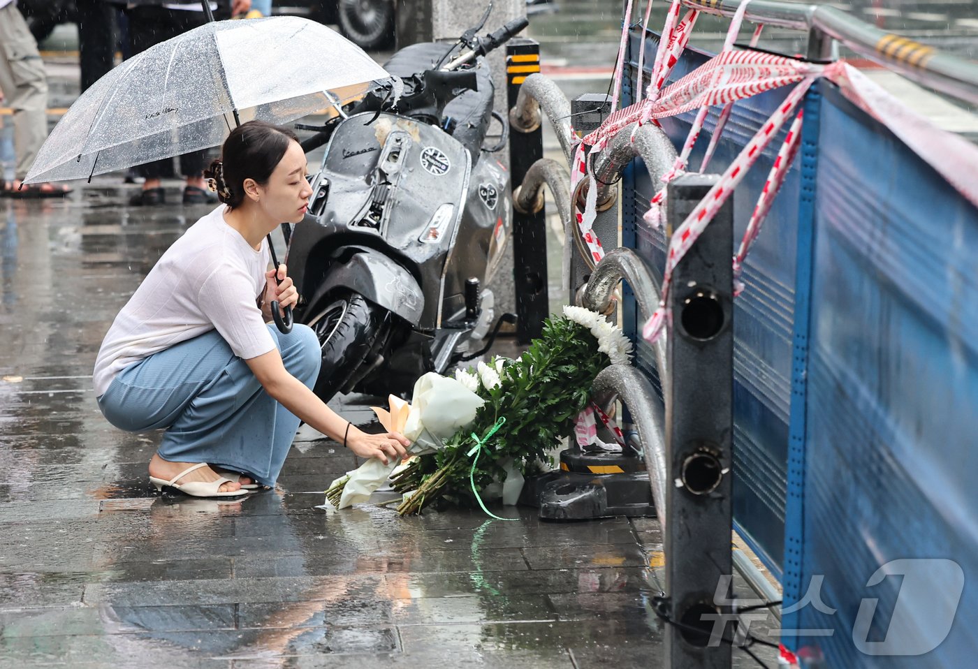 본문 이미지 - 지난밤 승용차가 인도로 돌진해 9명이 사망하는 사고가 발생한 2일 오전 서울 중구 서울시청 인근 교차로 사고현장에서 한 시민이 희생자를 추모하며 헌화를 하고 있다.  2024.7.2/뉴스1 ⓒ News1 김도우 기자
