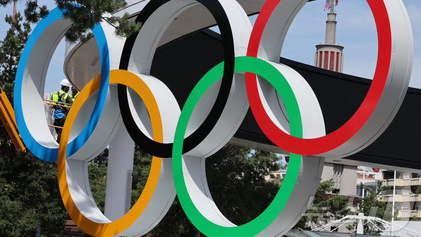 본문 이미지 - 2024 파리올림픽 개막을 엿새 앞둔 20일 오후&#40;한국시간&#41; 프랑스 사우스 파리 아레나4 입구에 설치된 오륜기 앞으로 대회 관계자들이 막바지 작업을 이어가고 있다. 2024.7.20/뉴스1 ⓒ News1 이동해 기자