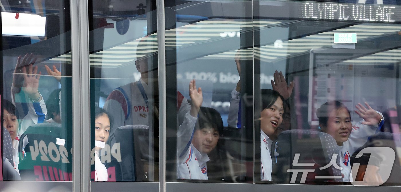 본문 이미지 - 2024 파리올림픽에 참가하는 북한 선수단 안창옥 선수 등이 21일 오후(한국시간) 프랑스 파리 샤를 드골 공항을 통해 입국해 버스에 올라 프랑스-조선 친선 환영단을 향해 손을 흔들고 있다. 2024.7.21/뉴스1 ⓒ News1 박정호 기자