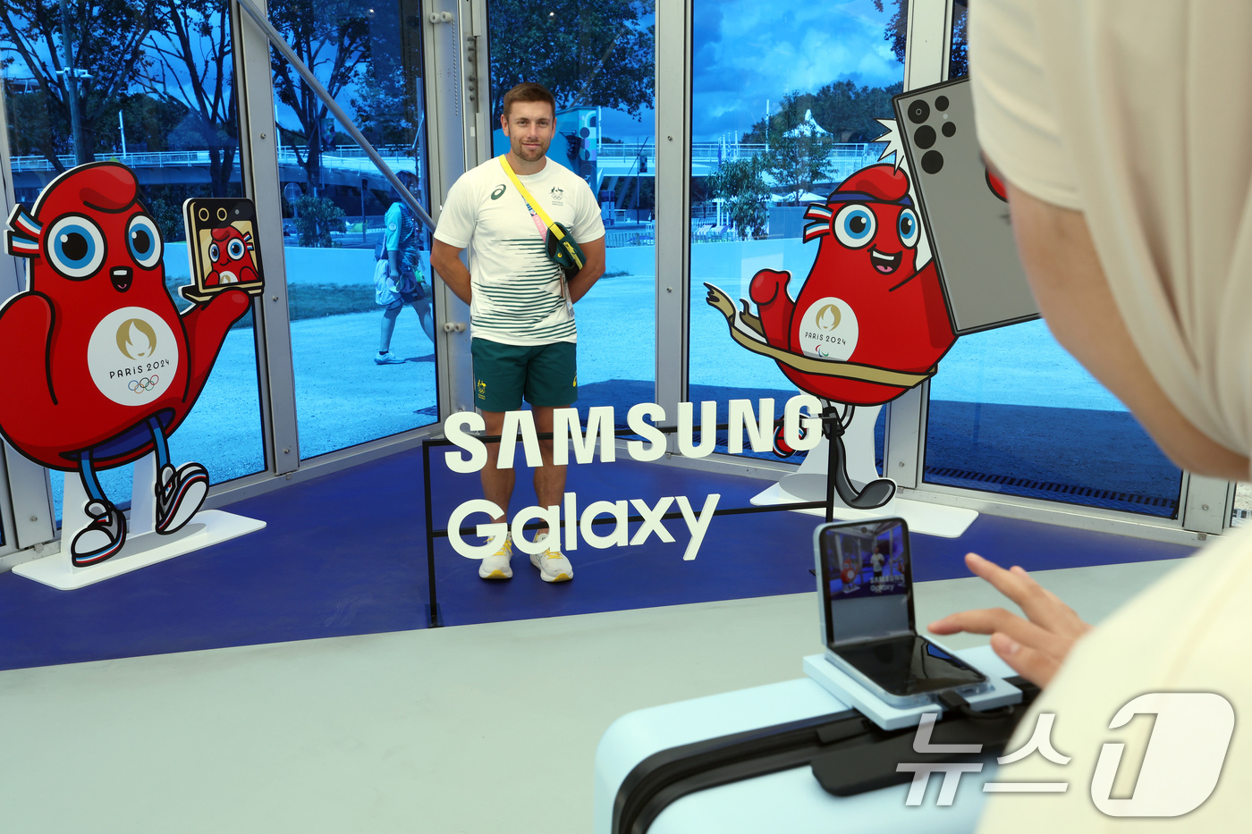 (파리(프랑스)=뉴스1) 박정호 기자 = 21일 오후(한국시간) 파리 생드니에 위치한 올림픽 선수촌 삼성전자 올림픽 체험관을 찾은 호주 선수단 관계자가 갤럭시 Z 플립6로 기념 사 …