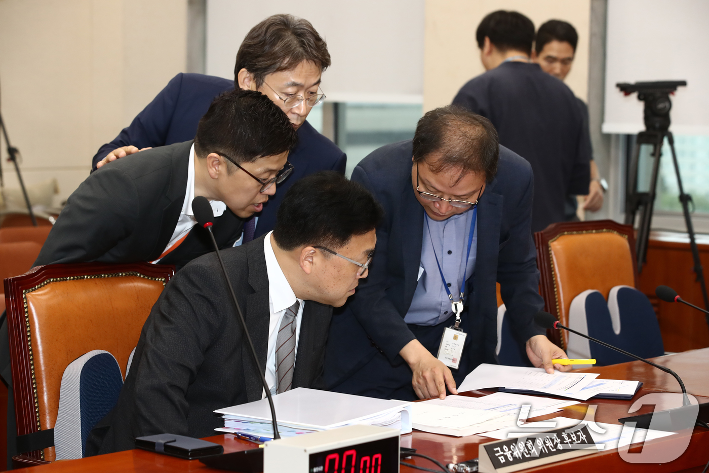 (서울=뉴스1) 이광호 기자 = 김병환 금융위원장 후보자가 22일 오전 서울 여의도 국회 정무위원회 전체회의장에서 열린 인사청문회에 출석해 관계자들과 자료를 보며 논의하고 있다. …