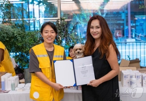본문 이미지 - 이지은 아크 기획위원장은 20일 성악가 신문희 씨에게 홍보대사 위촉장을 전달했다(아크보호소 제공). ⓒ 뉴스1