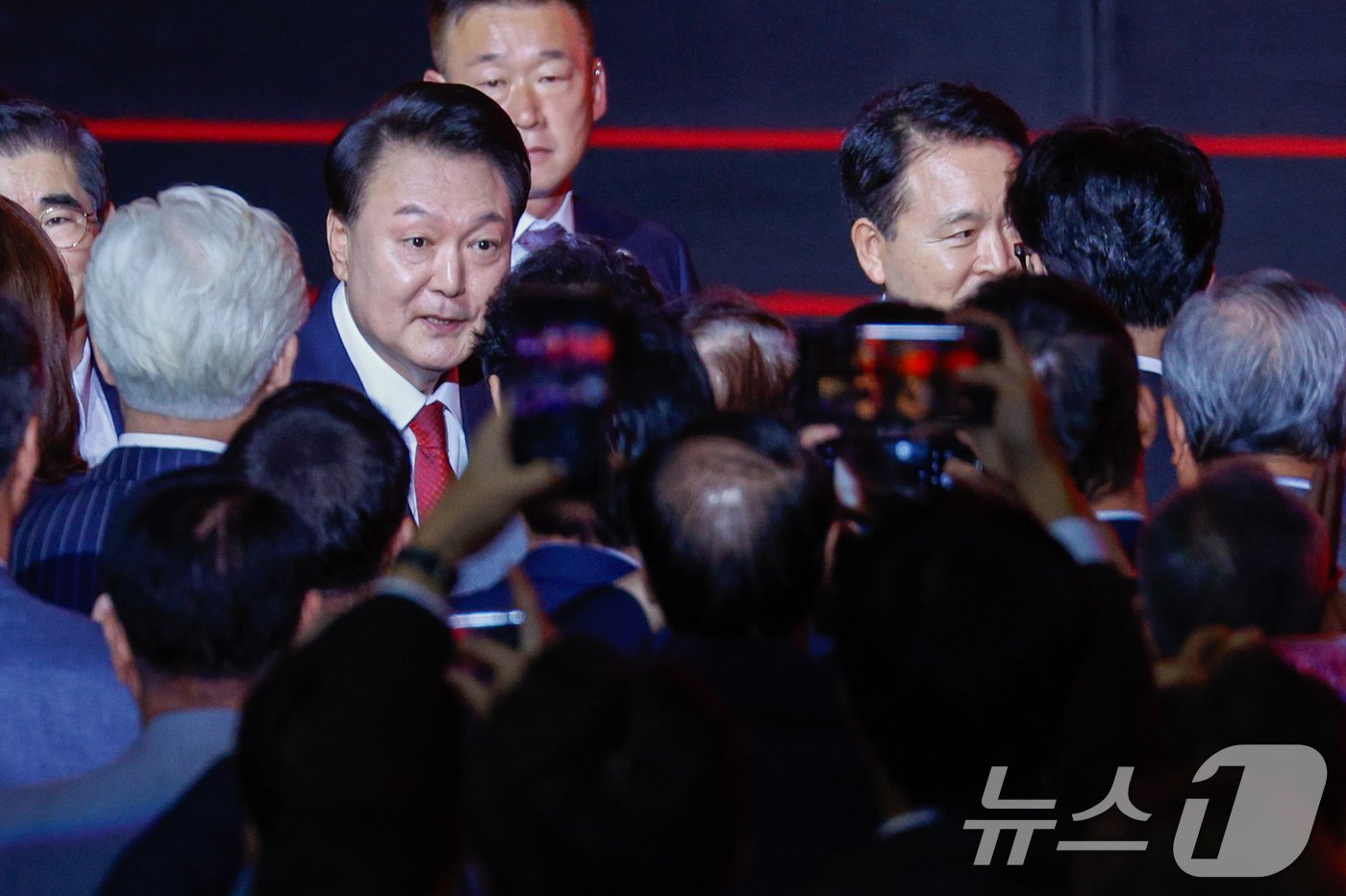 본문 이미지 - 윤석열 대통령이 23일 오후 경기 고양시 일산서구 킨텍스에서 열린 국민의힘 제4차 전당대회에 입장하며 참석자들과 인사하고 있다. 오른쪽 뒷모습은 한동훈 당대표 후보. 2024.7.23/뉴스1 ⓒ News1 안은나 기자