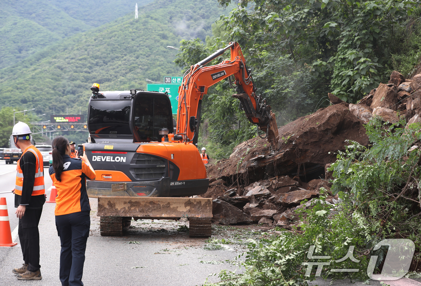 (안양=뉴스1) 김영운 기자 = 23일 오후 경기 안양시 만안구 수도권제1순환고속도로 안양에서 산본방향 산본IC 인근 경사면에서 토사가 흘러내려 도로 일부가 통제돼 관계자들이 복구 …