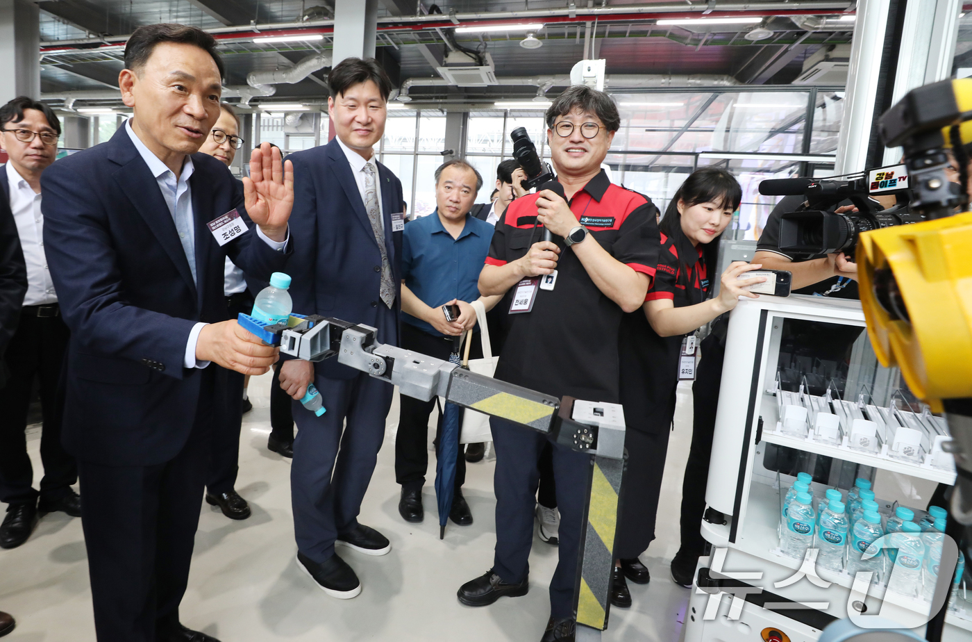 (서울=뉴스1) = 조성명 강남구청장이 23일 서울 강남구 수서동  ‘강남 로봇플러스 테스트필드’에서 열린 개소식 시설 투어에서 로봇에게 생수통을 건네받고 있다. (강남구청 제공) …