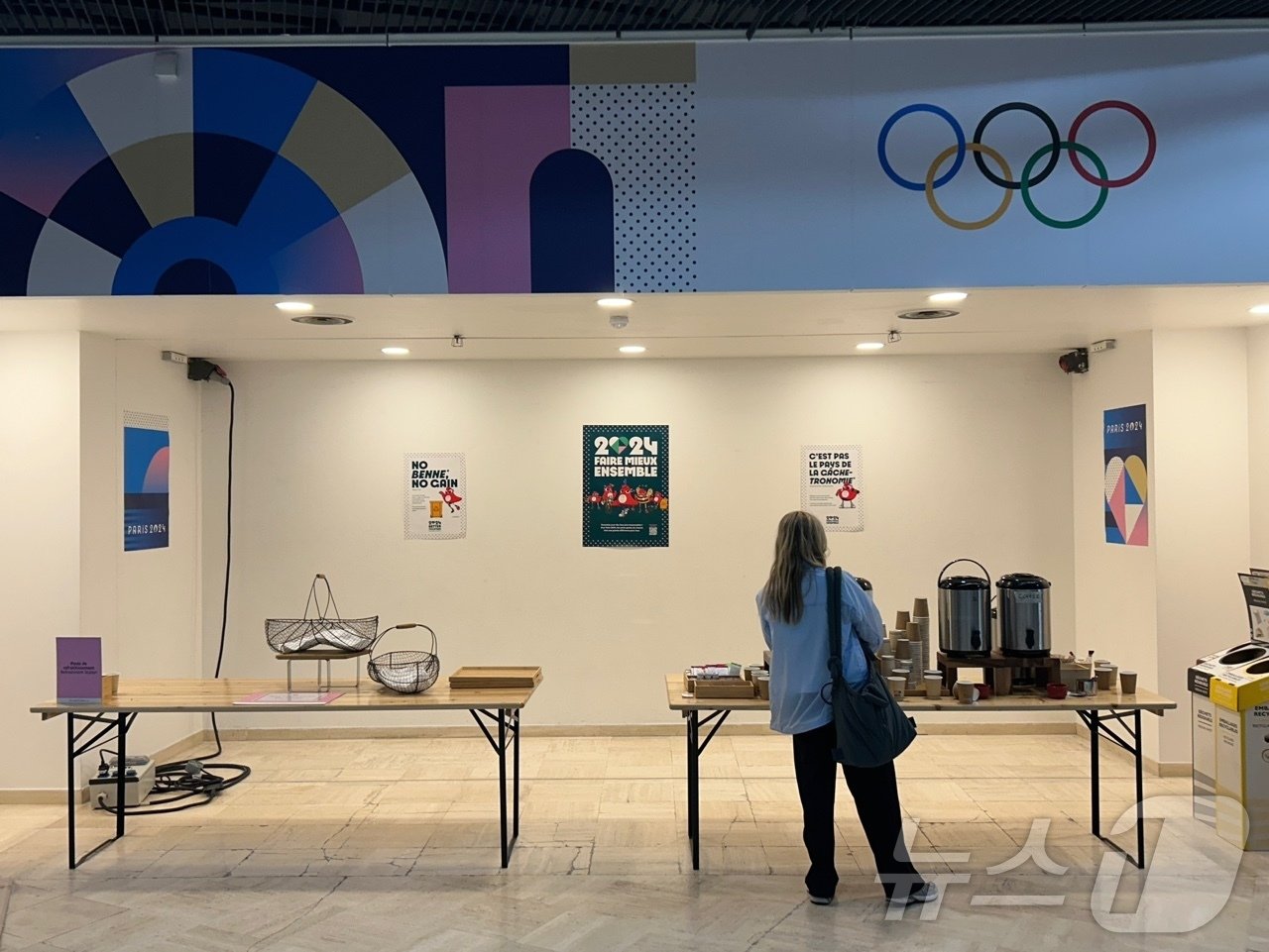 본문 이미지 -     23일(한국시간) 프랑스 파리의 팔레 데 콩그레에 마련된 메인프레스센터(MPC)의 모습. 한 외신 기자가 MPC 내 비치된 커피를 마시기 위해 서 있다. 2024.7.23/뉴스1 ⓒ News1 문대현 기자