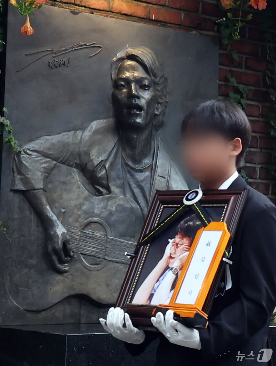 본문 이미지 - 20일 서울 종로구 대학로 아르코 꿈밭극장(옛 학전)에서 열린 고 김민기의 노제에서 영정이 운구되고 있다. 2024.7.24/뉴스1 ⓒ News1 김명섭 기자