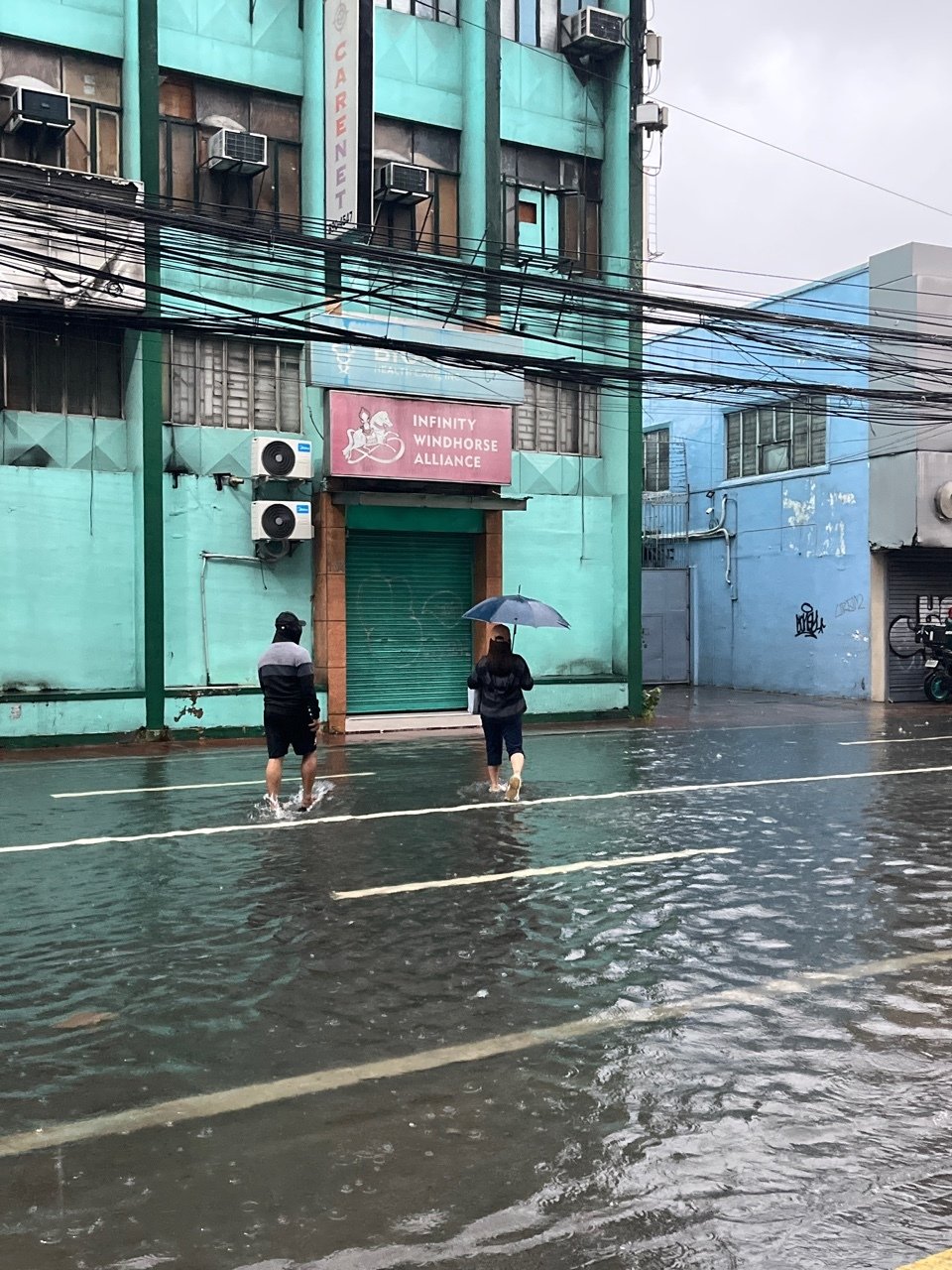 본문 이미지 - 24일(현지시간) 제3호 태풍 '개미'의 영향으로 필리핀 마닐라 도심 곳곳이 침수됐다. 사진은 폭우로 빗물이 종아리까지 차오른 마닐라 도심. 2024.07.24/ (독자 제공)