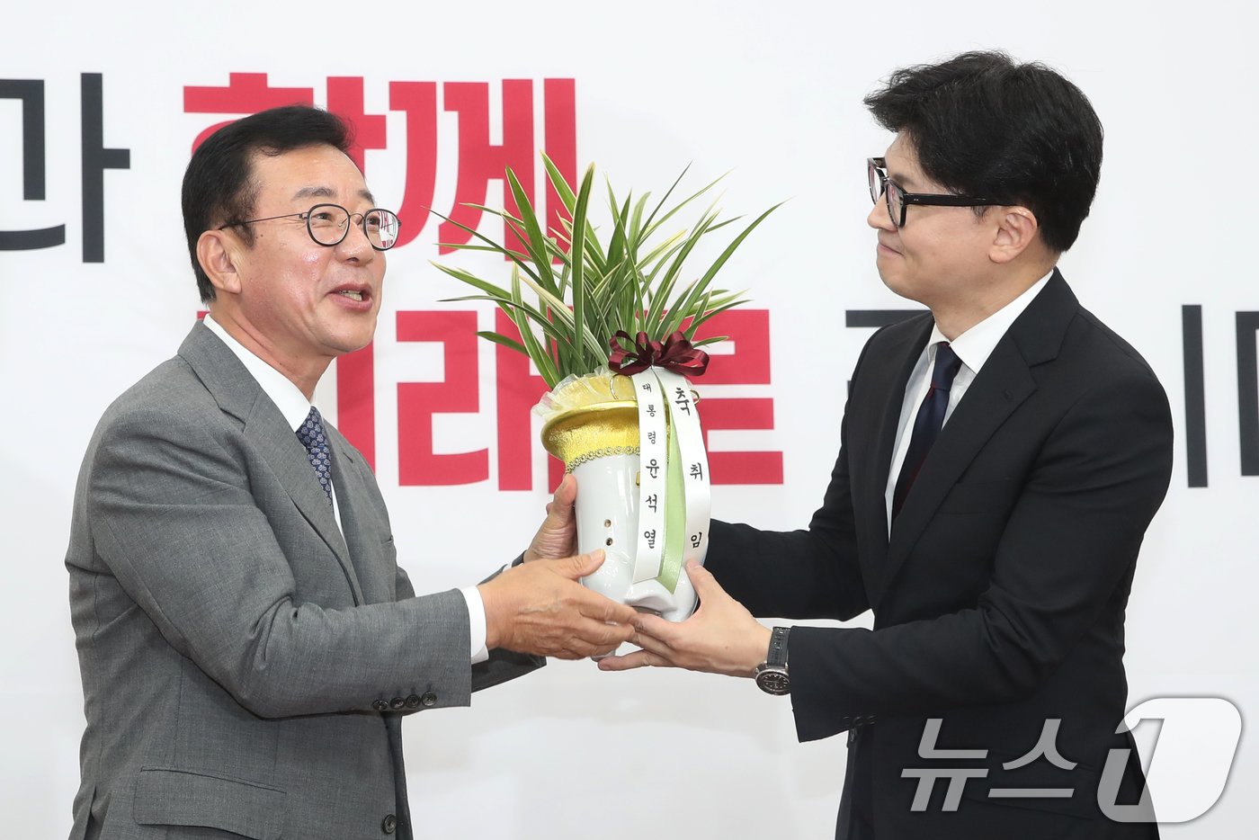 본문 이미지 - 한동훈 국민의힘 대표가 24일 오후 서울 여의도 국회를 찾은 홍철호 정무수석으로부터 윤석열 대통령의 축하난을 전달받고 있다. 2024.7.24/뉴스1 ⓒ News1 이광호 기자