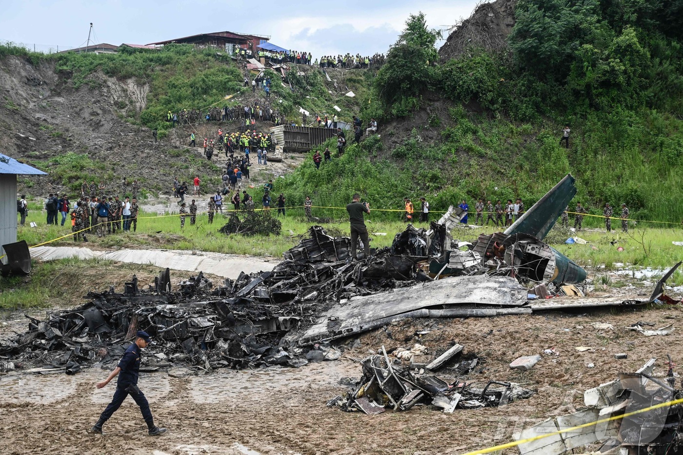 (카트만두 AFP=뉴스1) 정지윤기자 = 24일 네팔 카트만두 트리부반 국제공항에서 이륙중 추락한 사우랴항공 여객기의 잔해가 주변에 널려 있다. 포카라로 향하는 여객기에는 19명이 …