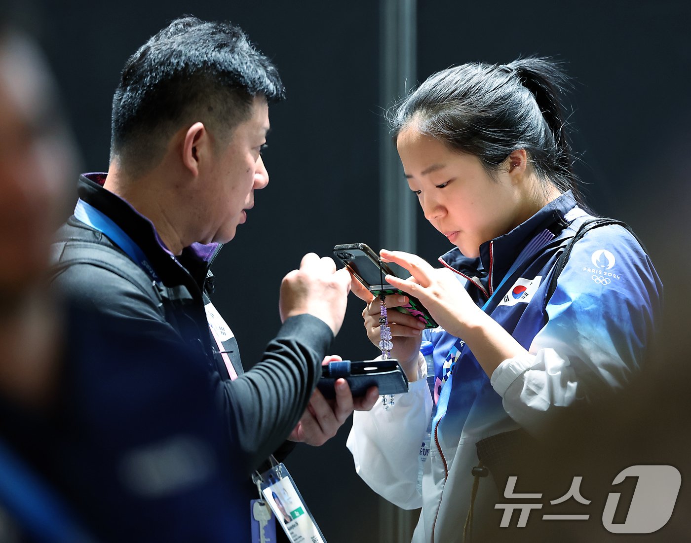 본문 이미지 - 대한민국 탁구대표팀 신유빈 선수가 25일 오전&#40;한국시간&#41; 프랑스 파리 사우스 파리 아레나4 기자회견장 밖에서 대진이 완성된 뒤 팀 관계자와 대화를 나누고 있다. 2024.7.25/뉴스1 ⓒ News1 박정호 기자