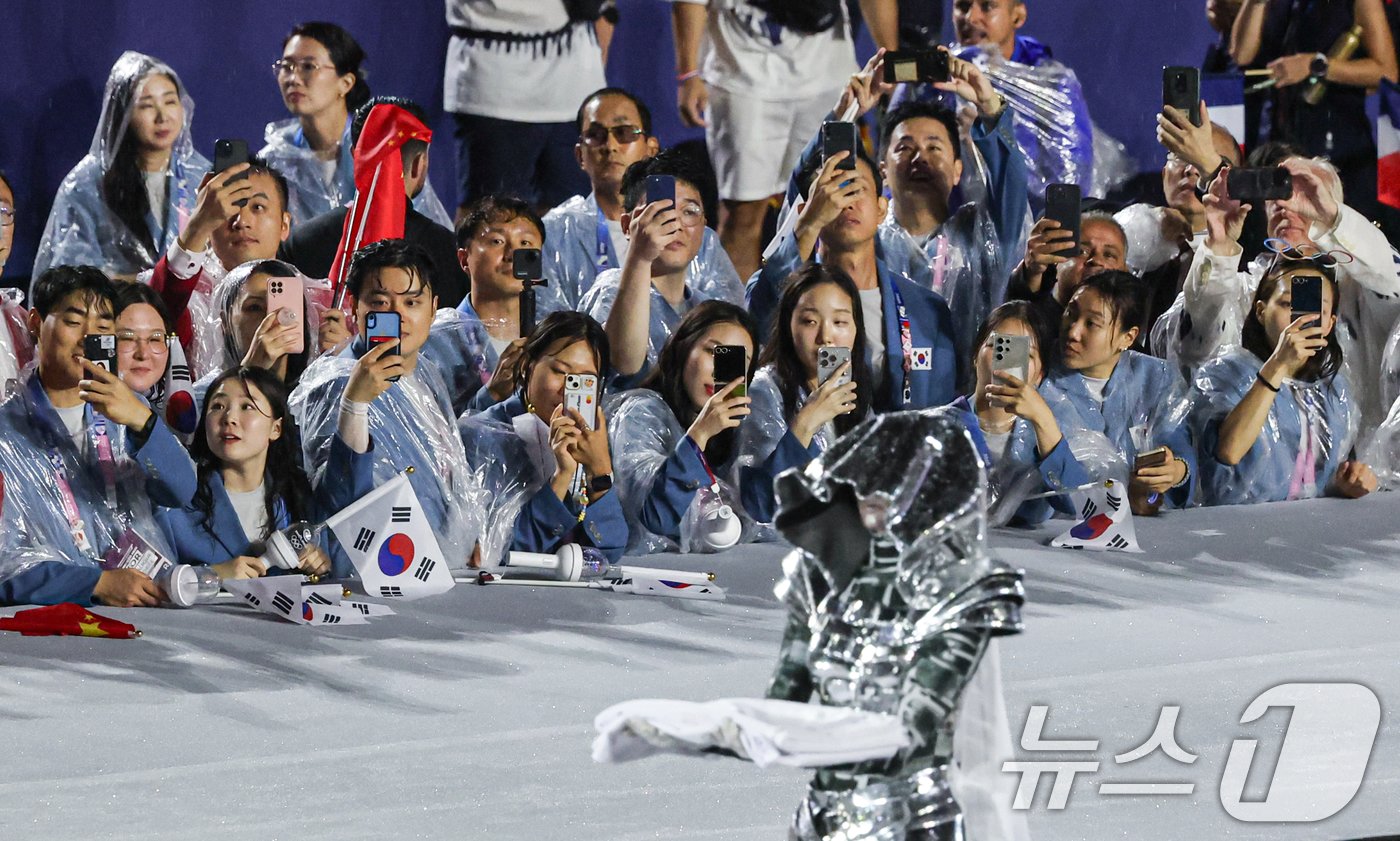본문 이미지 - 27일(한국시간) 프랑스 파리 트로카데로 광장에서 열린 2024 파리 올림픽 개회식에서 대한민국 선수단이 올림픽기를 손에 든 여성기사를 바라보고 있다. 2024.7.27/뉴스1 ⓒ News1 이동해 기자