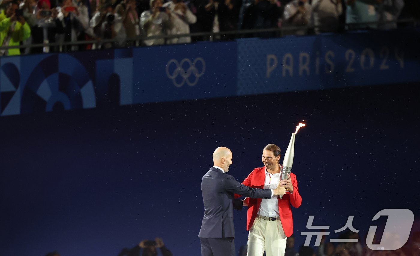 지네딘 지단이 27일&#40;한국시간&#41; 프랑스 파리 트로카데로광장에서 열린 2024 파리 올림픽 개회식에서 성화를 다음 주자인 라파엘 나달에게 전달하고 있다. &#40;공동취재&#41; 2024.7.27/뉴스1 ⓒ News1 이동해 기자