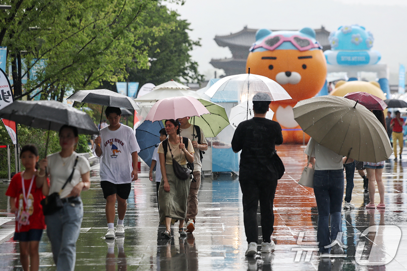 (서울=뉴스1) 민경석 기자 = 전국이 흐리고 곳곳에 비가 내린 27일 서울 종로구 광화문광장에서 우산을 쓴 시민들이 걸어가고 있다. 2024.7.27/뉴스1