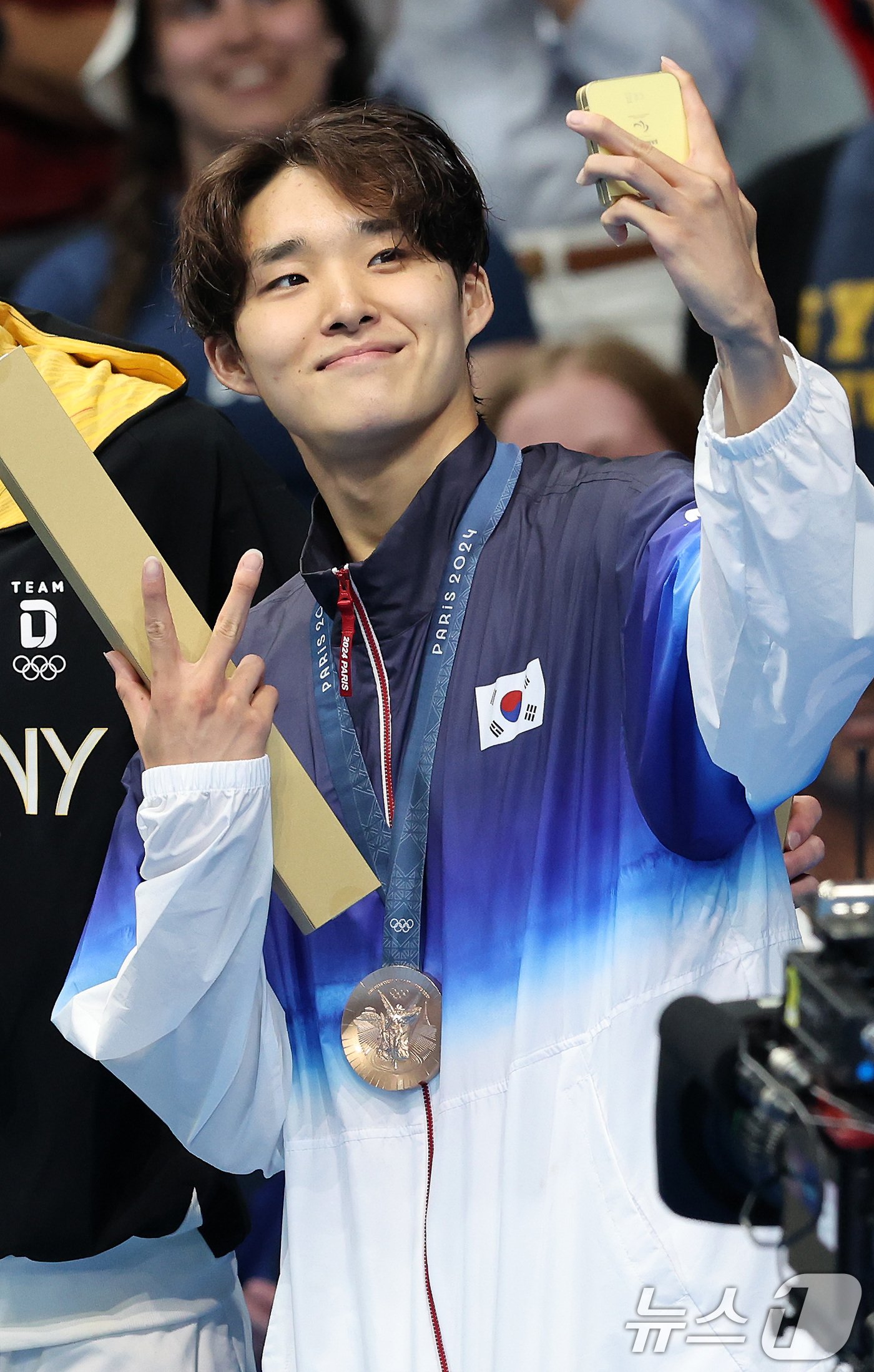 본문 이미지 - 동메달을 목에 건 대한민국 수영대표팀 김우민이 28일(한국시간) 프랑스 파리 라데팡스에서 열린 남자 400M 자유형 결승 시상식에서 갤럭시 Z플립6를 이용해 기념촬영을 하고 있다. 2024.7.28/뉴스1 ⓒ News1 이동해 기자
