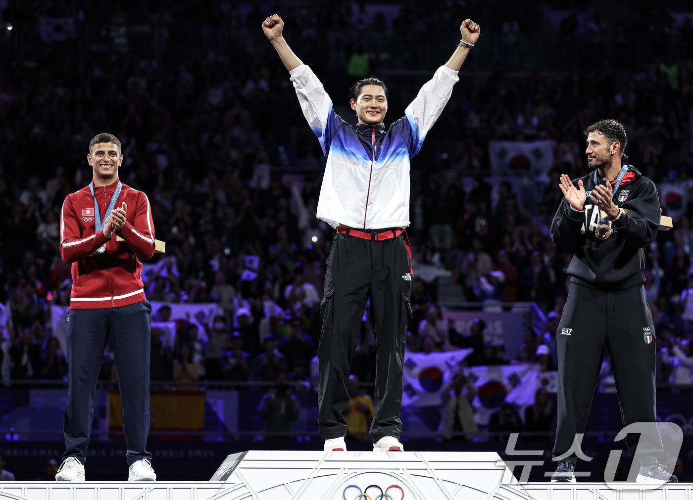 본문 이미지 - 대한민국 펜싱 대표팀 오상욱 선수가 28일(한국시간) 프랑스 파리 그랑 팔레에서 열린 2024 파리올림픽 남자 사브르 개인 결승 시상식에서 시상대에 오르며 두 손을 들어보이고 있다. 왼쪽부터 튀니지 파레스 페르자니(은메달), 오상욱(금메달), 이탈리아 루이지 지멜리(동메달). 2024.7.28/뉴스1 ⓒ News1 박정호 기자