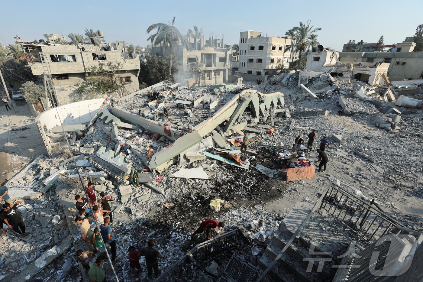 본문 이미지 - 27일(현지시간) 가자지구 중부 데이르알발라의 한 모스크가 이스라엘군의 공습으로 무너졌다. 사람들이 건물 잔해 주위에서 희생자 및 생존자를 수색하고 있다. 2024.07.27/ ⓒ 로이터=뉴스1 ⓒ News1 권진영 기자