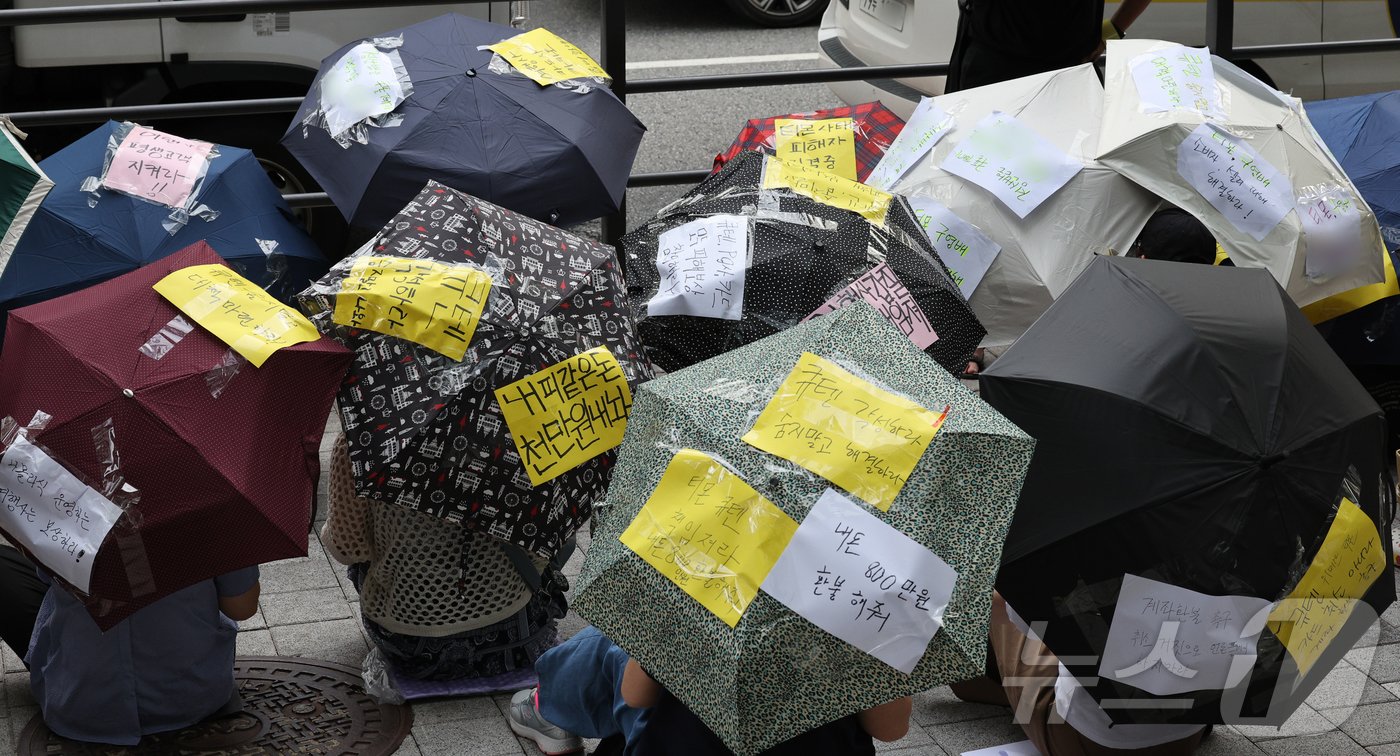 티몬과 위메프의 정산·환불 지연 사태가 지속되고 있는 28일 오후 서울 강남구 큐텐 본사 앞에서 피해자들이 사태 해결을 촉구하는 문구를 붙인 우산을 쓴 채 시위하고 있다. 2024.7.28/뉴스1 ⓒ News1 장수영 기자