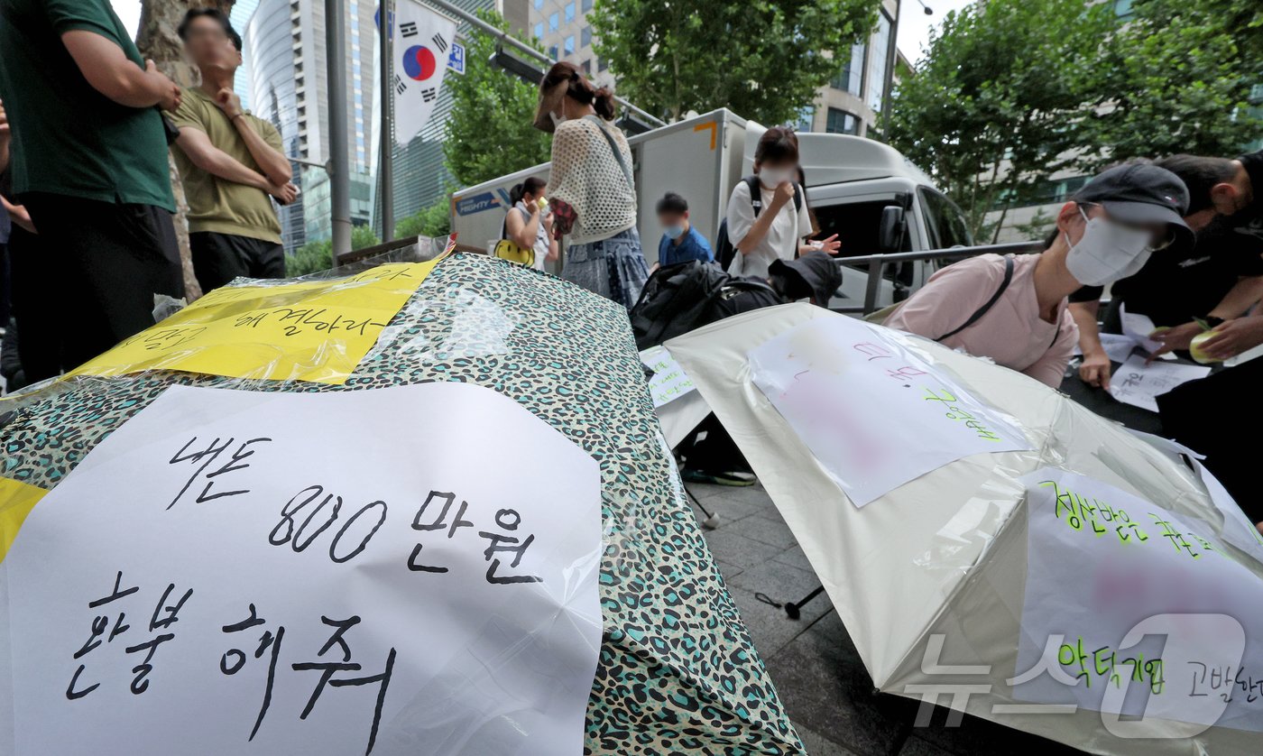 본문 이미지 - 티몬과 위메프의 정산·환불 지연 사태가 지속되고 있는 28일 오후 서울 강남구 큐텐 본사 앞에서 피해자들이 사태 해결을 촉구하는 문구를 우산에 붙이며 시위를 준비하고 있다. 2024.7.28/뉴스1 ⓒ News1 장수영 기자