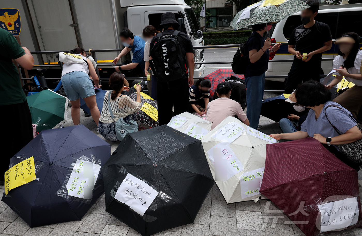 (서울=뉴스1) 장수영 기자 = 티몬과 위메프의 정산·환불 지연 사태가 지속되고 있는 28일 오후 서울 강남구 큐텐 본사 앞에서 피해자들이 사태 해결을 촉구하는 문구를 우산에 붙이 …