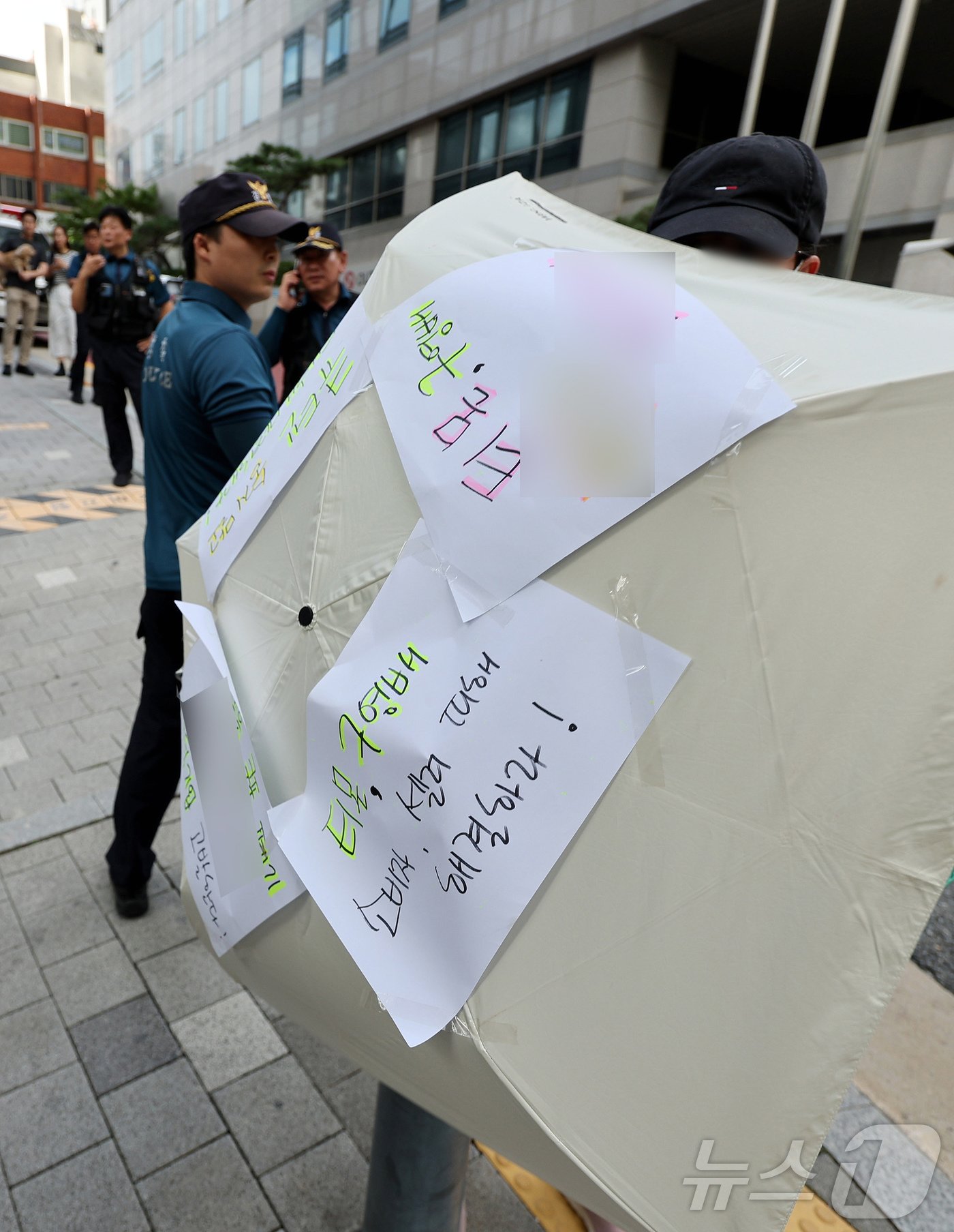 티몬과 위메프의 정산·환불 지연 사태가 지속되고 있는 28일 오후 서울 강남구 큐텐 본사 앞에서 피해자가 사태 해결을 촉구하는 문구를 붙인 우산으로 시위하고 있다. 2024.7.28/뉴스1 ⓒ News1 장수영 기자