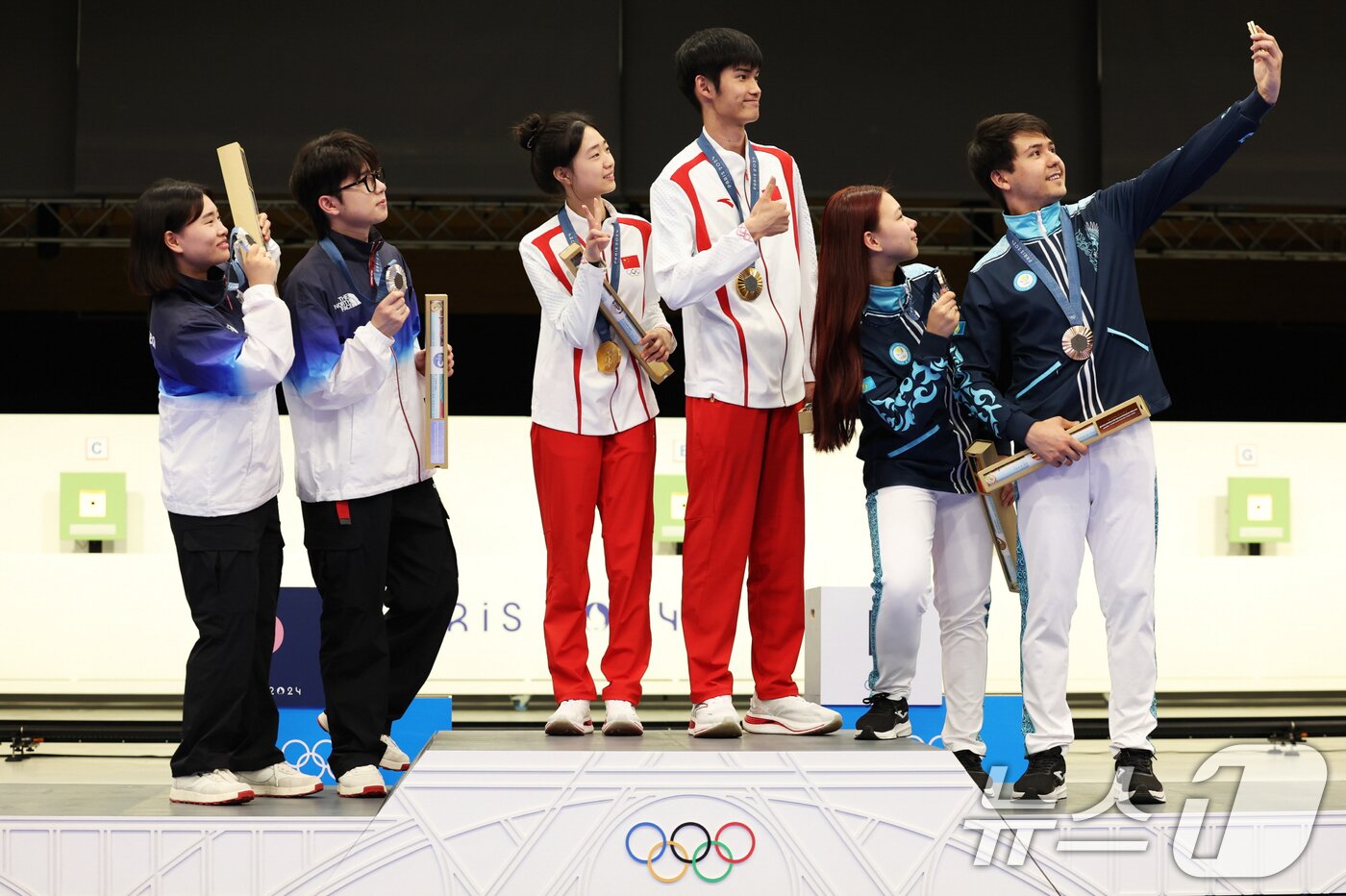 27일&#40;현지시간&#41; 프랑스 샤토루 슈팅센터&#40;Chateauroux Shooting Centre&#41;에서 열린 2024 파리 올림픽 사격 공기소총 10m 혼성 단체전 시상식에서 은메달 금지현, 박하준&#40;이상 대한민국&#41;, 금메달 황 위팅&#40;Yuting Huang&#41;, 성 리하오&#40;Lihao Sheng, 이상 중국&#41;, 동메달 알렉산드라 르&#40;Alexandra Le&#41;, 이슬람 사트파예프&#40;Islam Satpayev, 이상 카자흐스탄&#41; 선수들이 시상대에서 갤럭시 Z 플립6 올림픽 에디션으로 빅토리 셀피를 찍고 있다. &#40;삼성전자·게티이미지 제공&#41; 2024.7.29/뉴스1